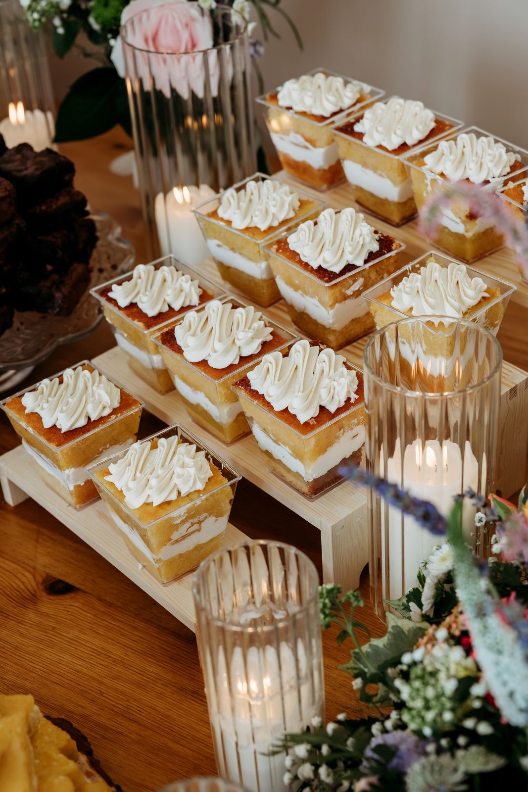 Cake pots on wooden risers with candles and flowers
