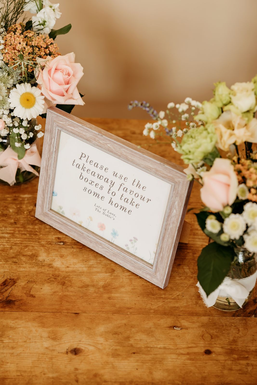 A sign inviting guests to take treats home in favour boxes